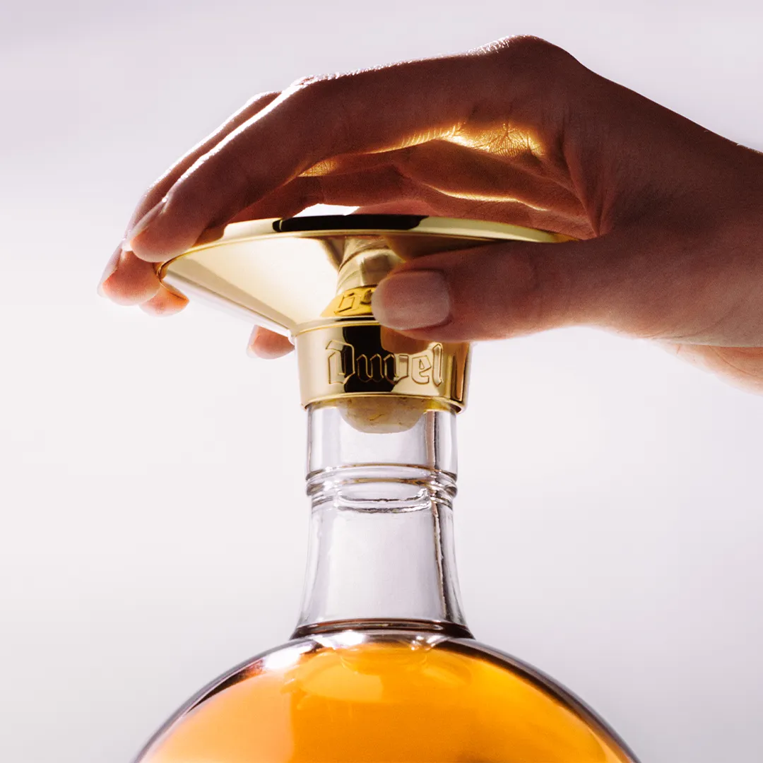 A hand opens a bottle of Marsla cask-aged Duvel Distilled.