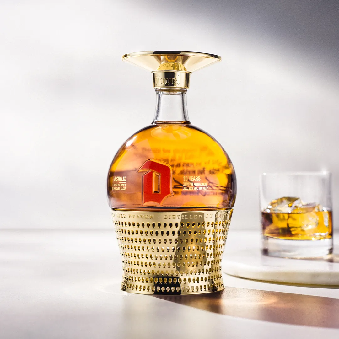 Packshot of a bottle of Duvel Distilled aged in Marsala casks next to a glass.