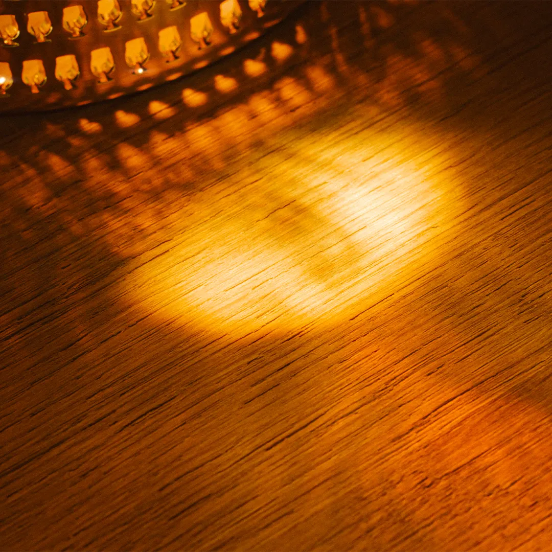 Wood texture illuminated by a bottle of Duvel Distilled.